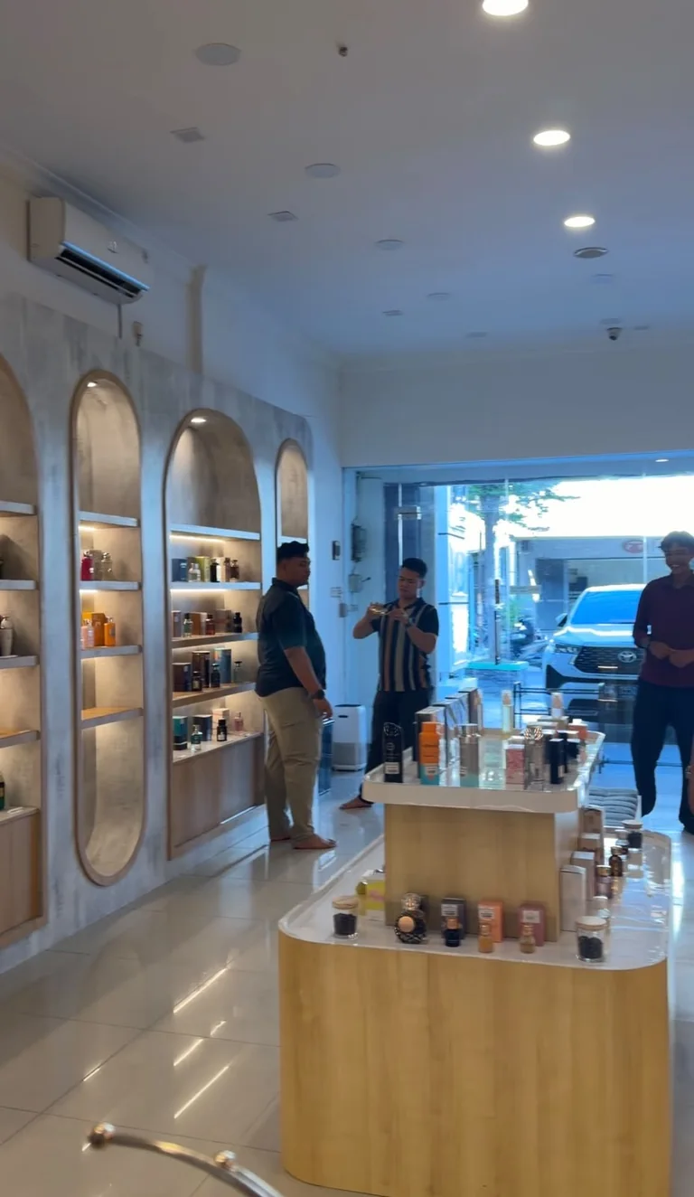 Suasana interior Qammaris dengan pengunjung dan meja koleksi parfum