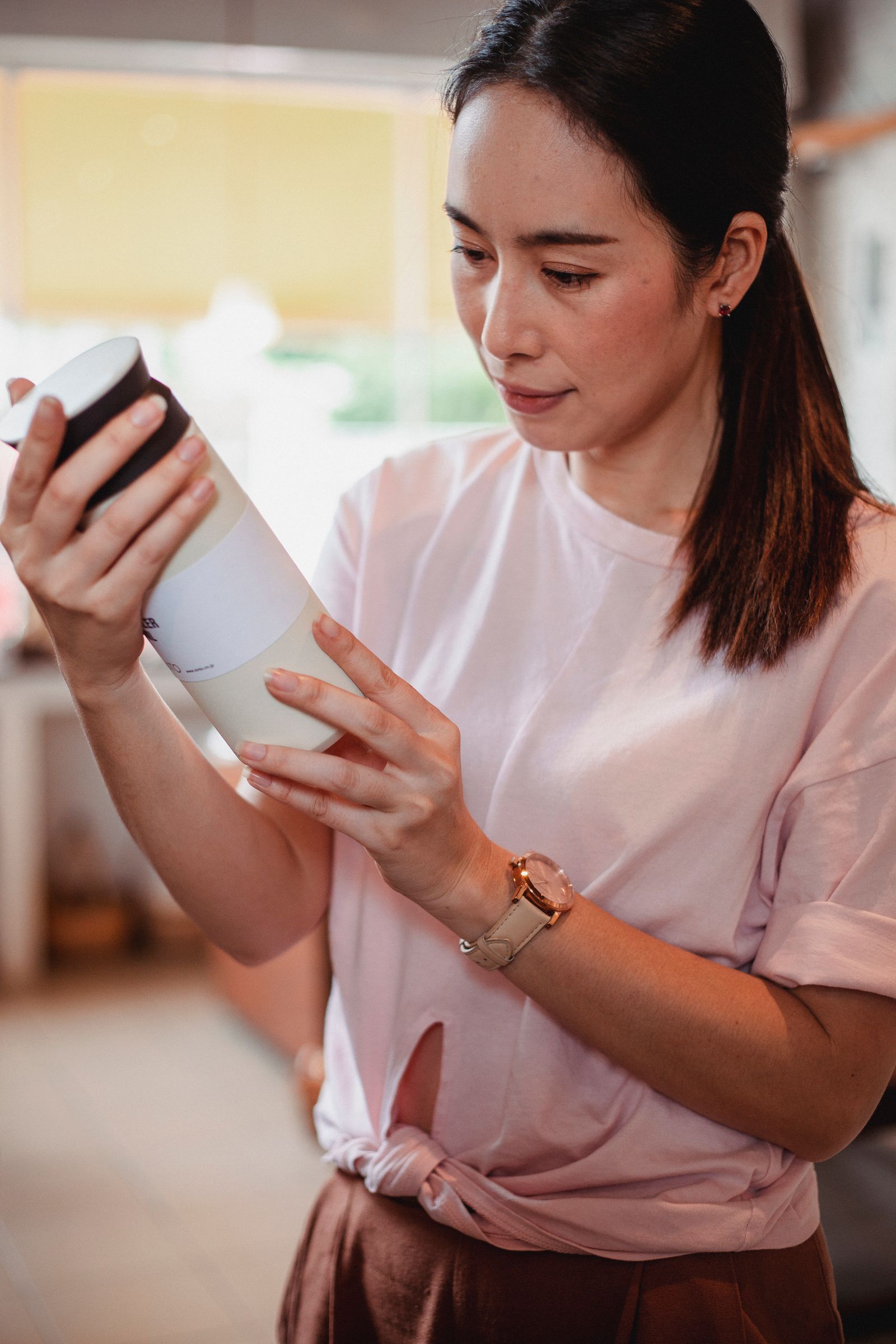 Seorang pembeli membaca label pada kemasan kosmetik di toko.